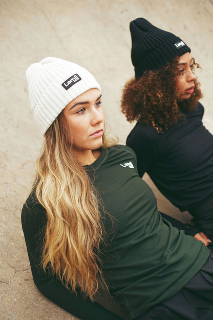 Lemii Label - Two people wearing beanies and athletic tops. against a neutral background