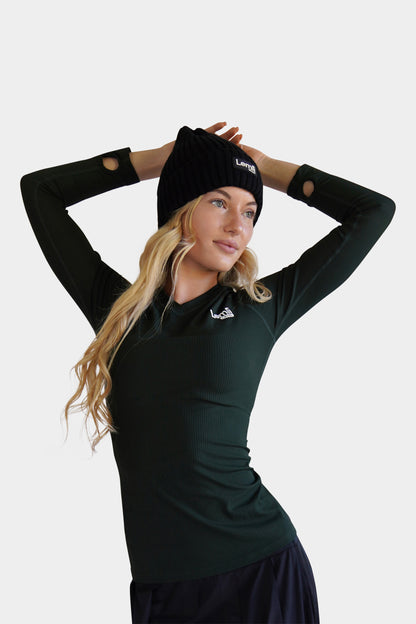Lemii Label - Woman with hands behind a black ribbed Lemii Label hat and wearing a green v neck athletic top - white background. 