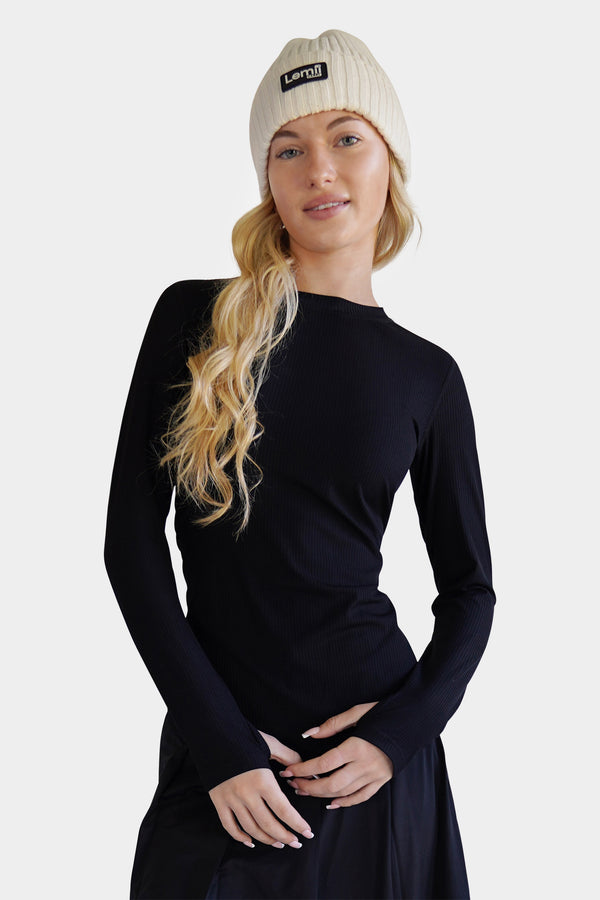 Lemii Label - Woman wearing a white ribbed hat - black athletic top - white background. 