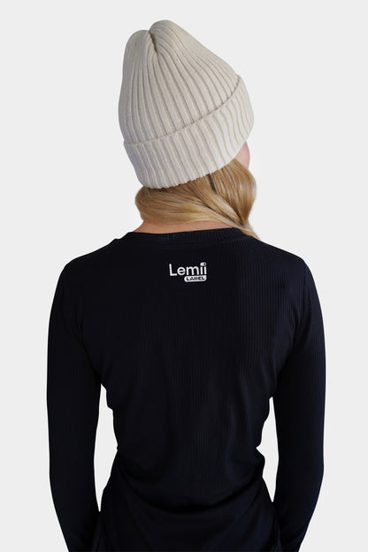 Lemii Label - Woman wearing a white ribbed hat - black athletic top - facing backwards - white background. 